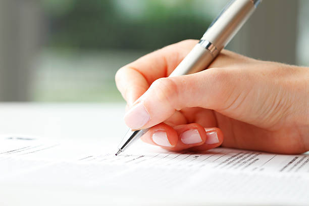 Patient filling out forms for VIP Fibroid with a pen.