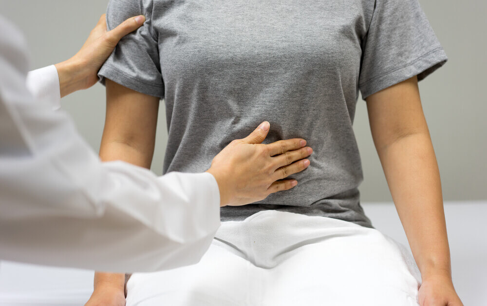 Doctor examining patient for pain caused by uterine fibroids.