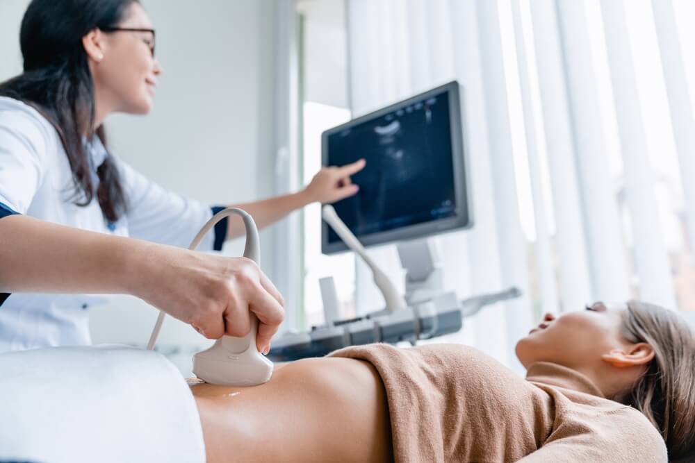 A doctor performing an ultrasound on a woman with uterine fibroids.