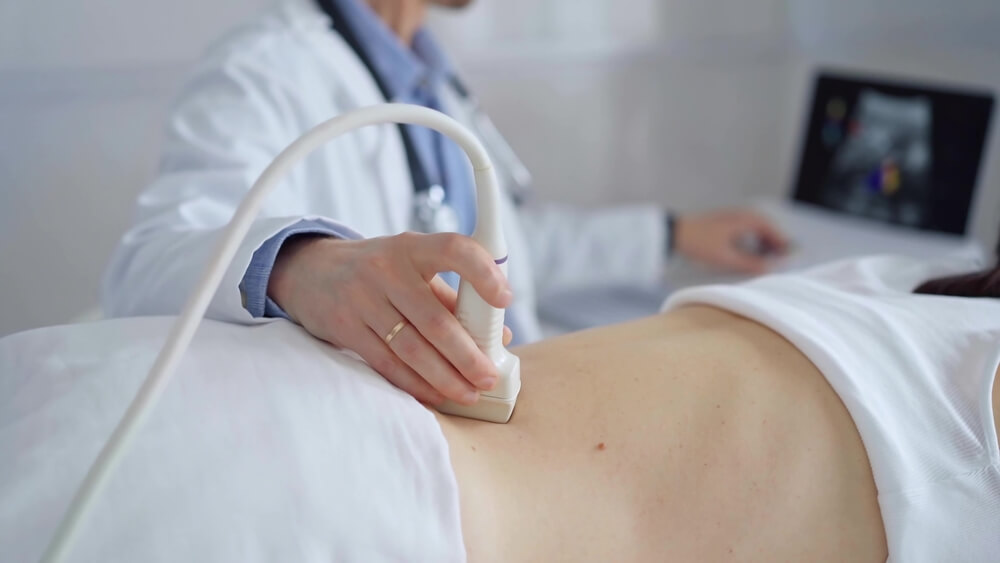 A technician completing an ultrasound to diagnose uterine fibroids.