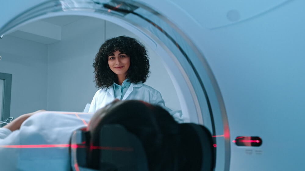 A doctor conducting an MRI on a woman for MRgFUS fibroid treatment