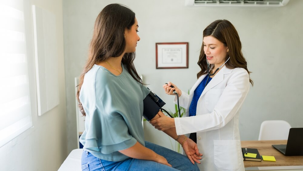 A doctor assessing a young women for uterine fibroids.