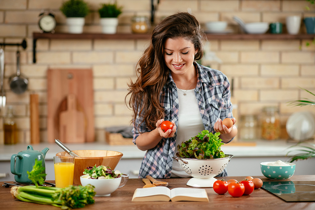 A woman undergoing UFE cooking a healthy meal in her kitchen