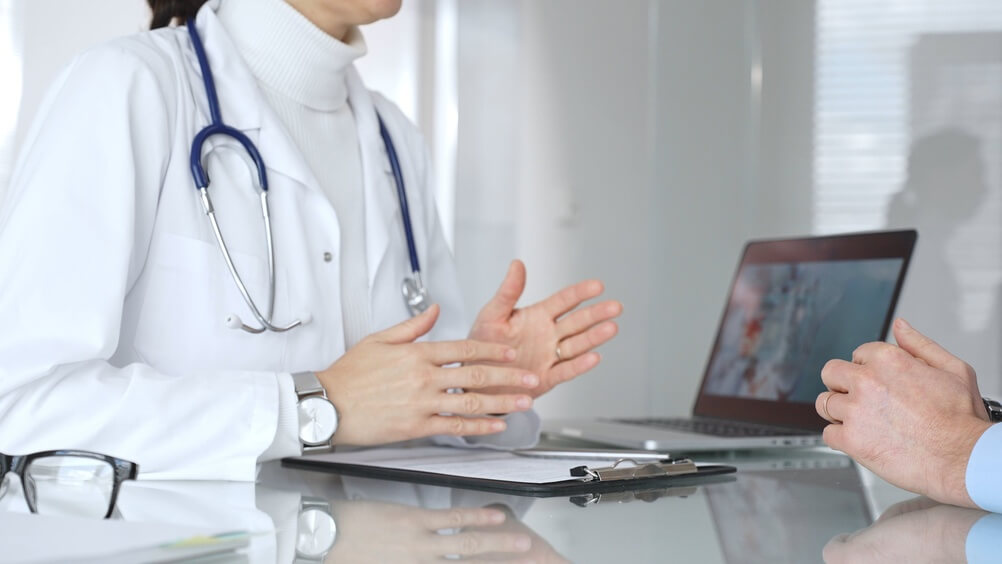 Doctor consulting patient, explaining treatment results during medical visit at clinic, providing healthcare advice. Medicine, healthcare and science concept
